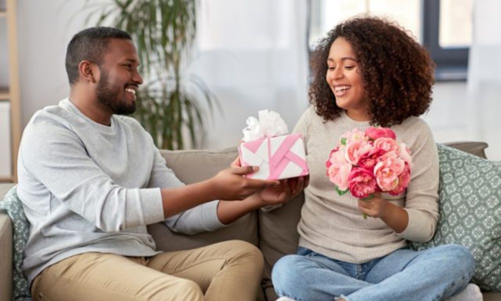 Man giving a wrapped present to his partner symbolizing gifts as a love language