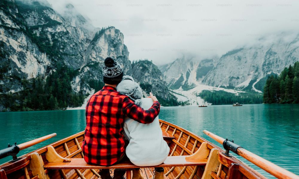Couple enjoying a romantic boat ride in scenic mountains representing special experiences as gifts in love language