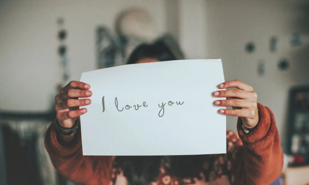 Person holding a handwritten note that says "I love you," symbolizing Words of Affirmation love language