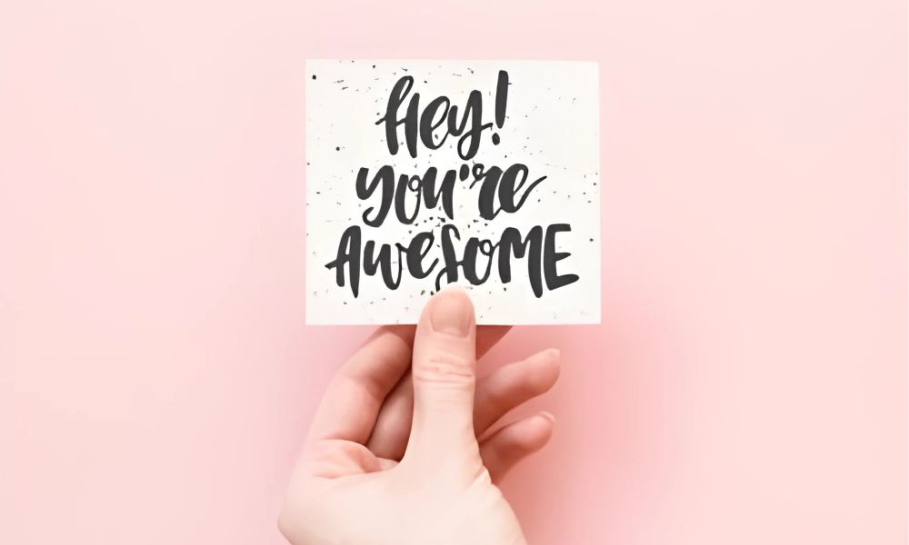 Hand holding a card with message Hey You're Awesome representing the Words of Affirmation love language
