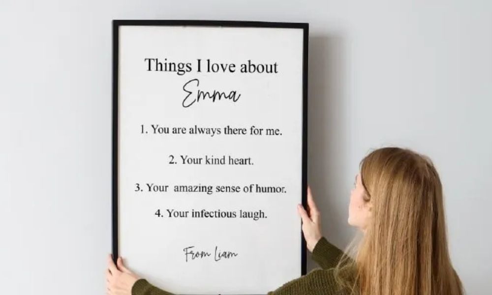 Woman holding a framed poster listing things she loves about someone, showing examples of Words of Affirmation love language